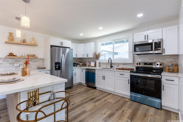 91-1327 Imelda St, Ewa Beach, HI 96706 - kitchen featuring appliances with stainless steel finishes, a sink, decorative backsplash, white cabinets, and a peninsula