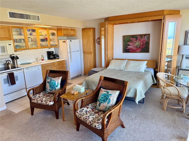 84-680 Kili Dr Unit 1001, Waianae, HI 96792 - bedroom with freestanding refrigerator, light colored carpet, a textured ceiling, a sink, and light tile patterned floors