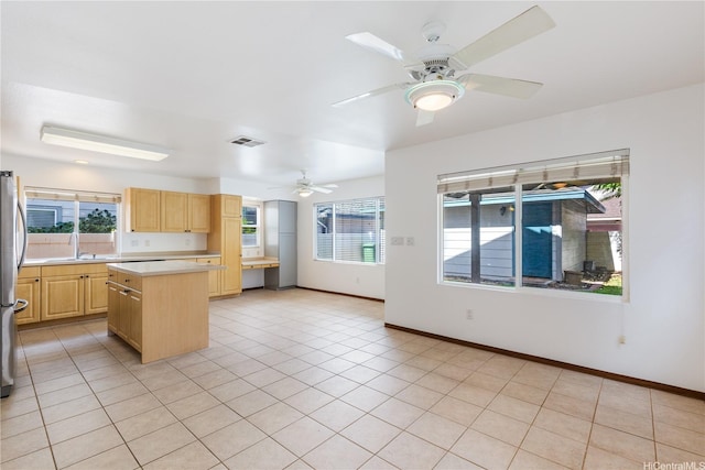 91-1022 Kaikauhaa St, Ewa Beach, HI 96706 - kitchen with light brown cabinets, a ceiling fan, light countertops, freestanding refrigerator, and a kitchen island