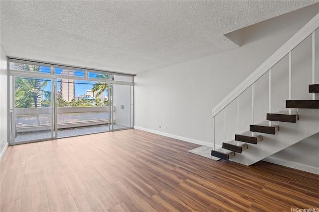 500 University Ave Unit 509, Honolulu, HI 96826 - unfurnished living room with a textured ceiling, stairs, floor to ceiling windows, wood finished floors, and baseboards