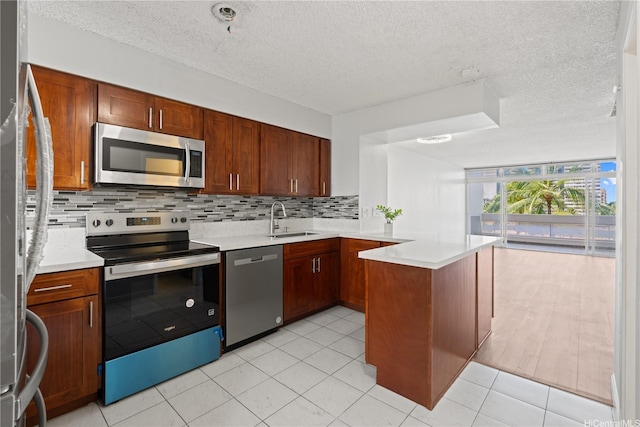 500 University Ave Unit 509, Honolulu, HI 96826 - kitchen featuring stainless steel appliances, a peninsula, a sink, backsplash, and light countertops