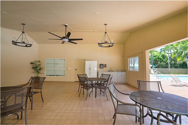 3009 Ala Makahala Pl Unit 905, Honolulu, HI 96818 - dining room with high vaulted ceiling, light tile patterned floors, a chandelier, and a ceiling fan