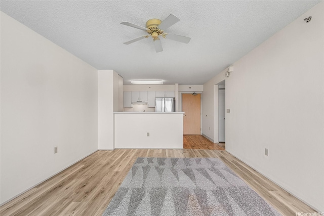 3009 Ala Makahala Pl Unit 905, Honolulu, HI 96818 - unfurnished living room featuring light wood-style floors, ceiling fan, and a textured ceiling