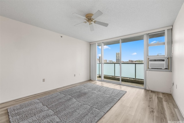 3009 Ala Makahala Pl Unit 905, Honolulu, HI 96818 - unfurnished room with ceiling fan, cooling unit, plenty of natural light, a wall of windows, and wood finished floors