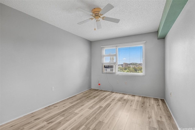 3009 Ala Makahala Pl Unit 905, Honolulu, HI 96818 - spare room featuring light wood-style flooring, a textured ceiling, a ceiling fan, and cooling unit