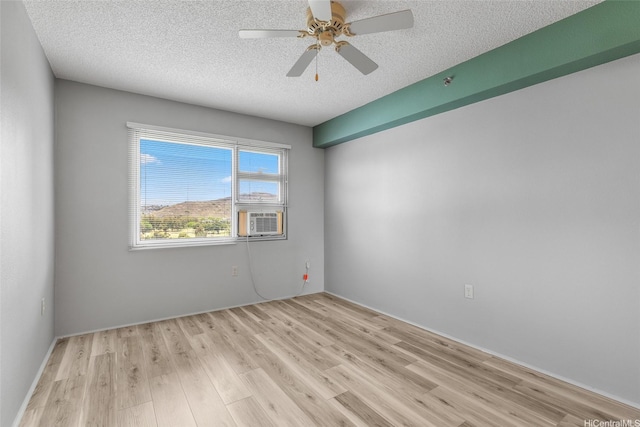 3009 Ala Makahala Pl Unit 905, Honolulu, HI 96818 - unfurnished room featuring light wood-style floors, a textured ceiling, a ceiling fan, and cooling unit