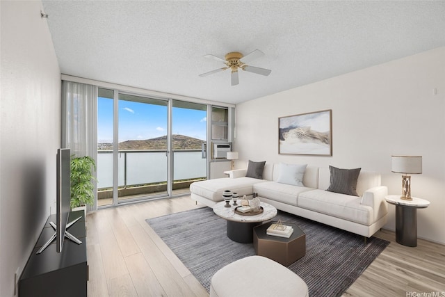 3009 Ala Makahala Pl Unit 905, Honolulu, HI 96818 - living area with floor to ceiling windows, ceiling fan, wood finished floors, and a textured ceiling