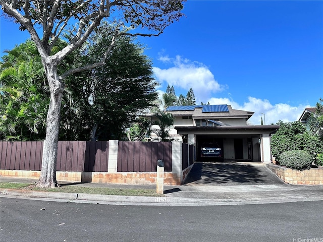 94-070 Akualele Pl, Mililani, HI 96789 - view of front facade with a fenced front yard, roof mounted solar panels, asphalt driveway, and a carport