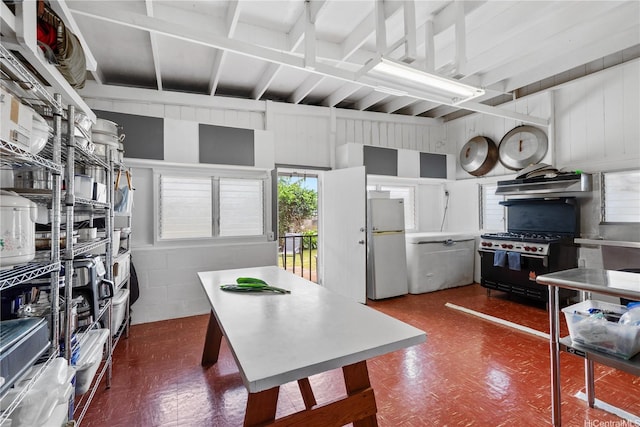 538 Akahi Pl, Lanai City, HI 96763 - kitchen with freestanding refrigerator, range with gas stovetop, dark flooring, under cabinet range hood, and beam ceiling