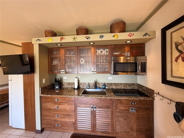 255 Kepuhi Pl Unit 4A02-1242, Maunaloa, HI 96770 - kitchen featuring stainless steel microwave, light tile patterned floors, black electric cooktop, glass insert cabinets, and dark stone counters