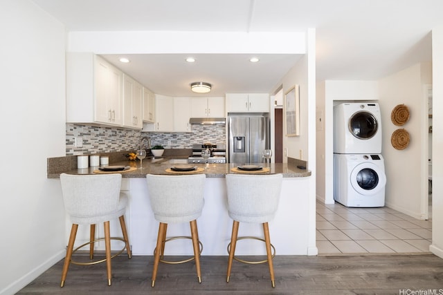 475 Atkinson Dr Unit 608, Honolulu, HI 96814 - kitchen with appliances with stainless steel finishes, stacked washer / drying machine, a peninsula, under cabinet range hood, and recessed lighting