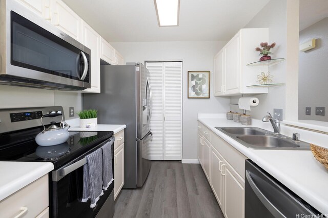 92-1151 Palahia St Unit B206, Kapolei, HI 96707 - kitchen featuring appliances with stainless steel finishes, a sink, wood finished floors, white cabinetry, and light countertops