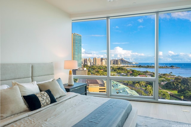 1118 Ala Moana Blvd Unit 1000, Honolulu, HI 96814 - bedroom featuring a water view, wood finished floors, multiple windows, a wall of windows, and a city view