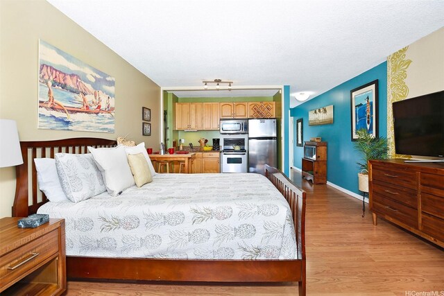 2345 Ala Wai Blvd Unit 1805, Honolulu, HI 96815 - bedroom featuring freestanding refrigerator, light wood-type flooring, and baseboards