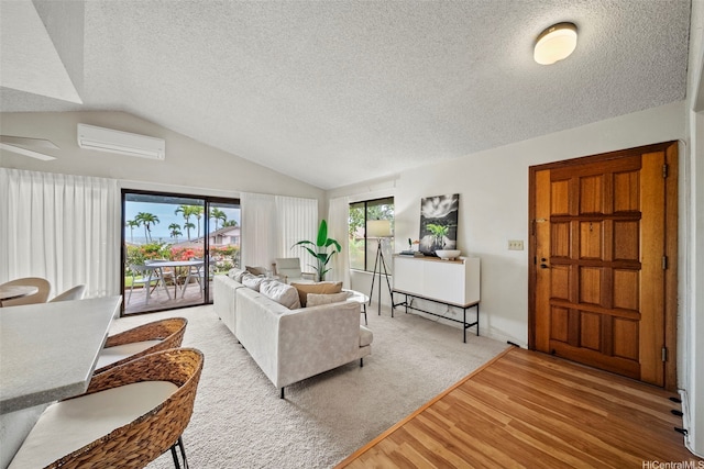 98-1712 Kaahumanu St Unit 11A, Pearl City, HI 96782 - living area with a wall unit AC, light wood finished floors, vaulted ceiling, a textured ceiling, and ceiling fan