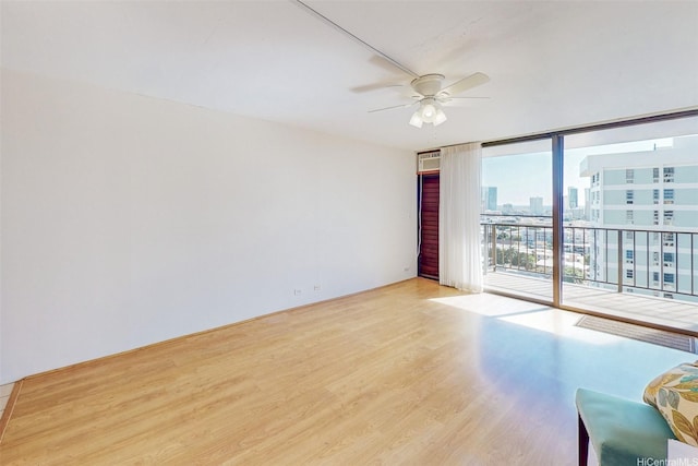 1630 Liholiho St Unit 1203, Honolulu, HI 96822 - empty room featuring ceiling fan, wood finished floors, a city view, and floor to ceiling windows