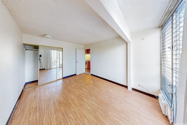 1911 Kalakaua Ave Unit 411, Honolulu, HI 96815 - unfurnished bedroom featuring a textured ceiling, light wood-style flooring, and baseboards