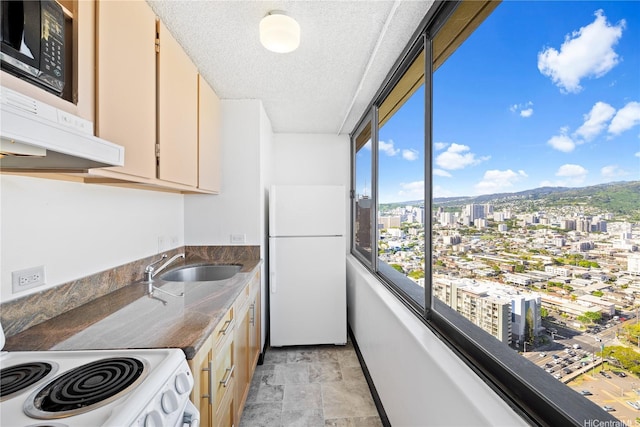 444 Niu St Unit 3806, Honolulu, HI 96815 - kitchen featuring white appliances, a city view, a sink, a textured ceiling, and stone finish floors