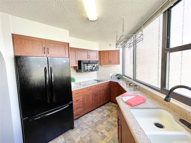 1221 Victoria St Unit 1205, Honolulu, HI 96814 - kitchen with black appliances, a sink, plenty of natural light, light countertops, and a textured ceiling