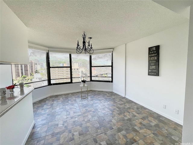 1221 Victoria St Unit 1205, Honolulu, HI 96814 - unfurnished dining area with a chandelier, stone finish floors, baseboards, and a textured ceiling