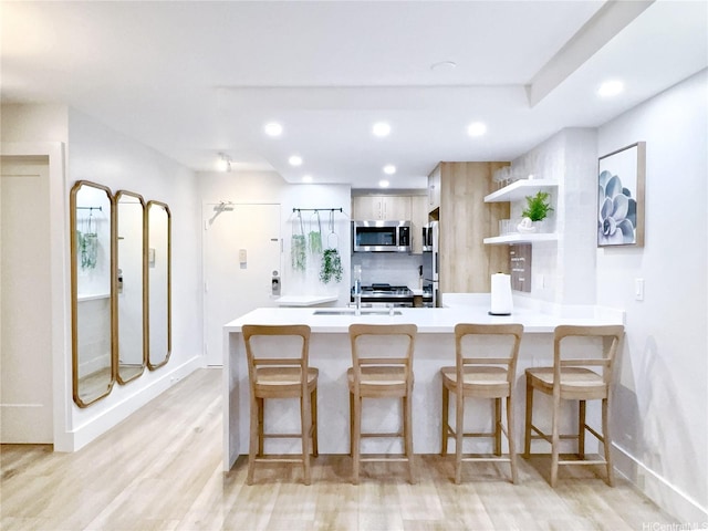 2465 Kuhio Ave Unit 1606, Honolulu, HI 96815 - kitchen with stainless steel appliances, open shelves, light wood finished floors, a peninsula, and recessed lighting