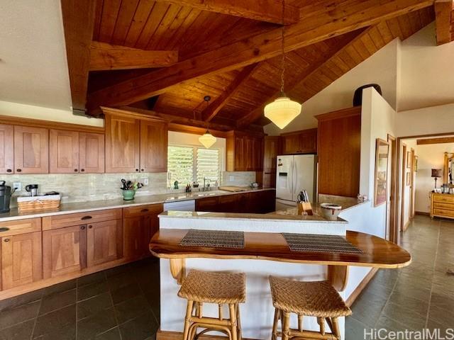 188 Ulua Rd, Kaunakakai, HI 96748 - kitchen with white fridge with ice dispenser, wood ceiling, pendant lighting, decorative backsplash, and light countertops