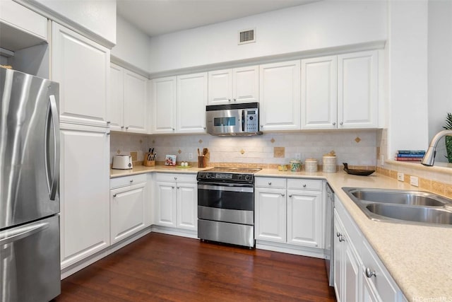 92-1164 Olani St Unit 47-3, Kapolei, HI 96707 - kitchen with appliances with stainless steel finishes, a sink, dark wood-style floors, tasteful backsplash, and light countertops