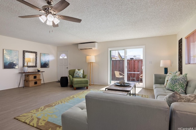 94-1444 Okupu St, Waipahu, HI 96797 - living room featuring wood finished floors, a textured ceiling, a wall mounted AC, and ceiling fan