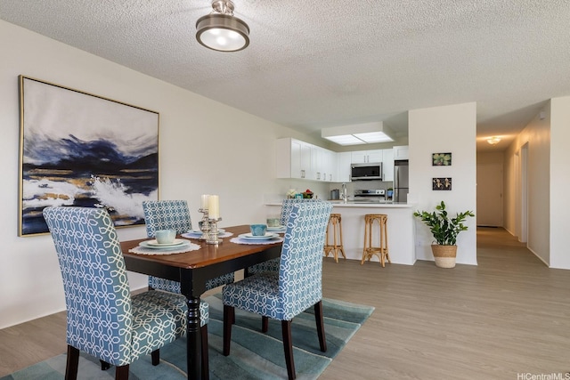 94-1444 Okupu St, Waipahu, HI 96797 - dining space with light wood-style floors and a textured ceiling