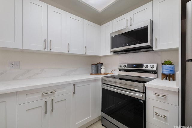94-1444 Okupu St, Waipahu, HI 96797 - kitchen with appliances with stainless steel finishes, white cabinets, and light stone counters