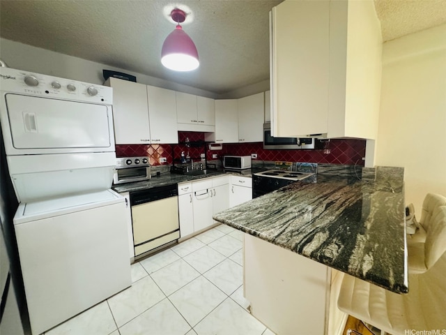 1615 Wilder Ave Unit 401, Honolulu, HI 96822 - kitchen featuring white appliances, stacked washer / drying machine, a peninsula, tasteful backsplash, and a textured ceiling