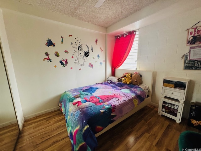 1615 Wilder Ave Unit 401, Honolulu, HI 96822 - bedroom with a textured ceiling, wood finished floors, a ceiling fan, and concrete block wall