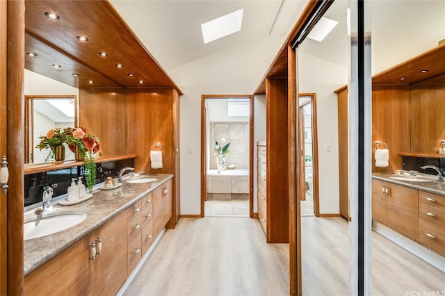 902 Wanaao Rd, Kailua, HI 96734 - full bathroom featuring a skylight, wood finished floors, double vanity, lofted ceiling, and a bath