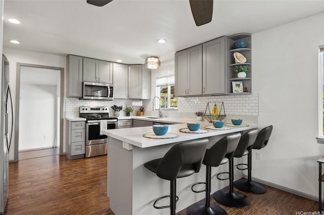 87-230 Holopono St, Waianae, HI 96792 - kitchen with appliances with stainless steel finishes, gray cabinets, dark wood-type flooring, a peninsula, and recessed lighting