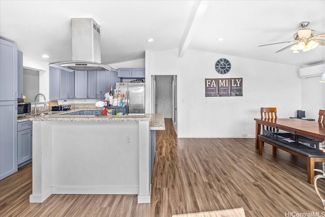 87-1698 Farrington Hwy Unit L, Waianae, HI 96792 - kitchen with island exhaust hood, appliances with stainless steel finishes, a wall mounted AC, wood finished floors, and a ceiling fan