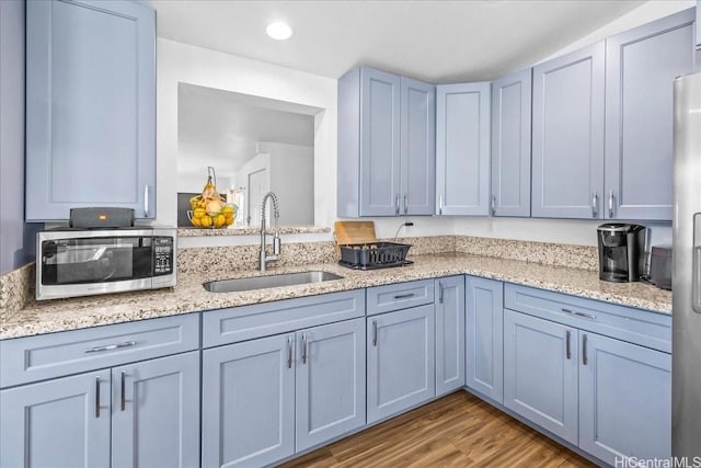87-1698 Farrington Hwy Unit L, Waianae, HI 96792 - kitchen featuring stainless steel microwave, a sink, light stone countertops, wood finished floors, and recessed lighting