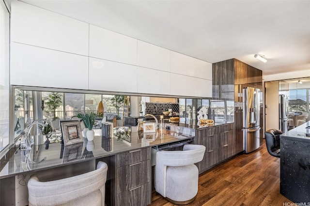 2825 S King St Unit 1403, Honolulu, HI 96826 - kitchen with modern cabinets, stainless steel refrigerator with ice dispenser, dark wood-type flooring, dark stone countertops, and stainless steel refrigerator