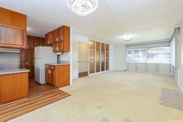 1157 Ala Aloalo St, Honolulu, HI 96818 - kitchen with freestanding refrigerator, light colored carpet, light countertops, brown cabinets, and a textured ceiling
