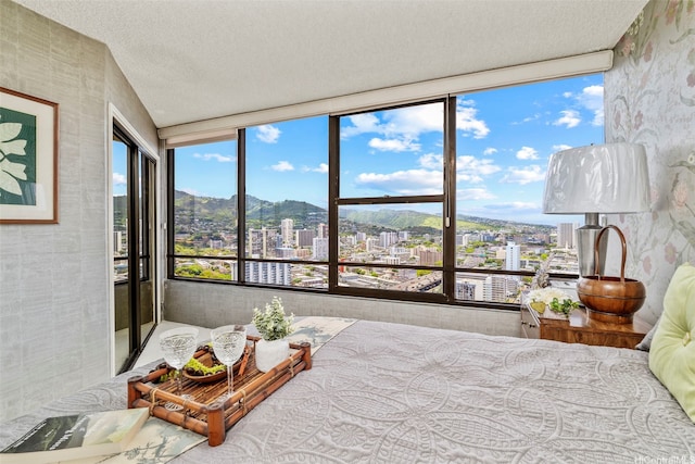 1221 Victoria St Unit 3205, Honolulu, HI 96814 - bedroom with a view of city, wallpapered walls, a textured ceiling, and a mountain view