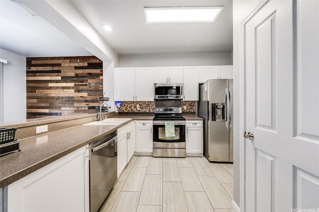 91-1200 Keaunui Dr Unit 204, Ewa Beach, HI 96706 - kitchen with appliances with stainless steel finishes, decorative backsplash, white cabinetry, and dark stone counters