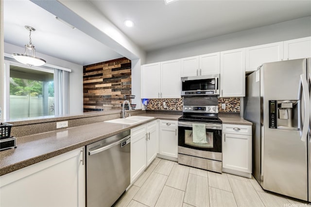91-1200 Keaunui Dr Unit 204, Ewa Beach, HI 96706 - kitchen with appliances with stainless steel finishes, backsplash, white cabinets, hanging light fixtures, and dark countertops