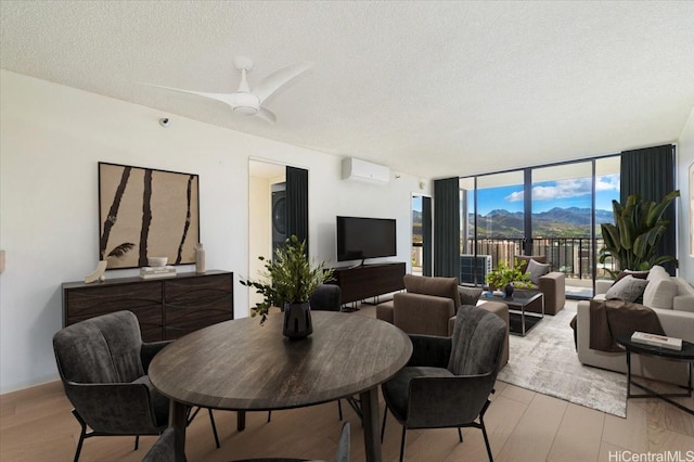990 Ala Nanala St Unit 27D, Honolulu, HI 96818 - dining room featuring wood finished floors, expansive windows, a textured ceiling, an AC wall unit, and ceiling fan