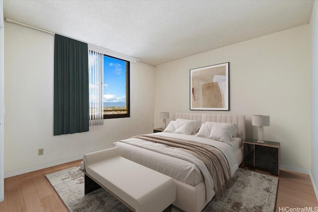 990 Ala Nanala St Unit 27D, Honolulu, HI 96818 - bedroom featuring wood finished floors, a textured ceiling, and baseboards
