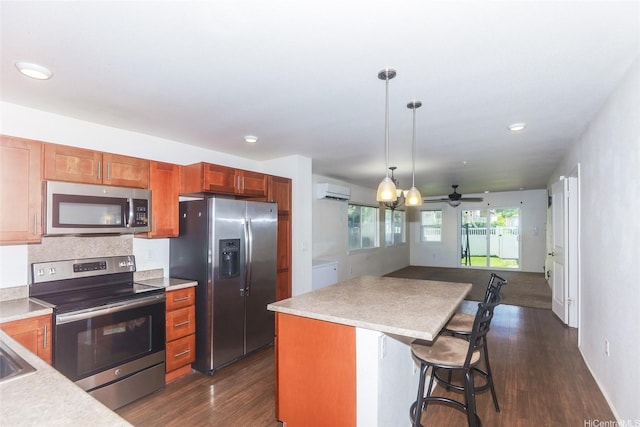 724 Kakala St Unit 1801, Ewa Beach, HI 96706 - kitchen featuring appliances with stainless steel finishes, dark wood-type flooring, a kitchen island, hanging light fixtures, and light countertops