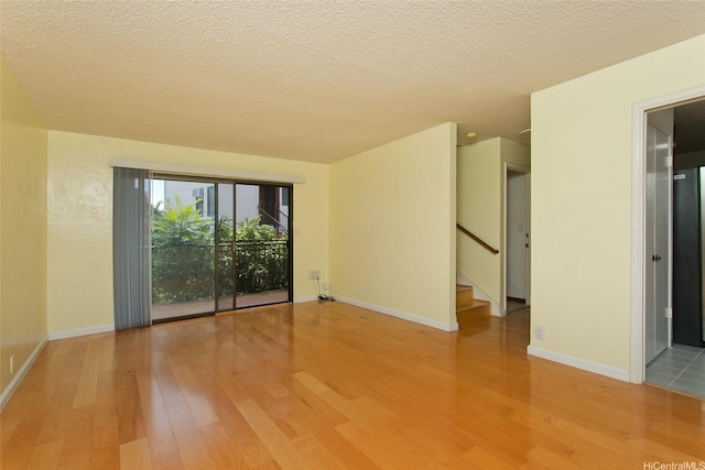 98-364 Kaonohi St Unit 11/386, Aiea, HI 96701 - unfurnished room featuring wood finished floors, stairs, and a textured ceiling