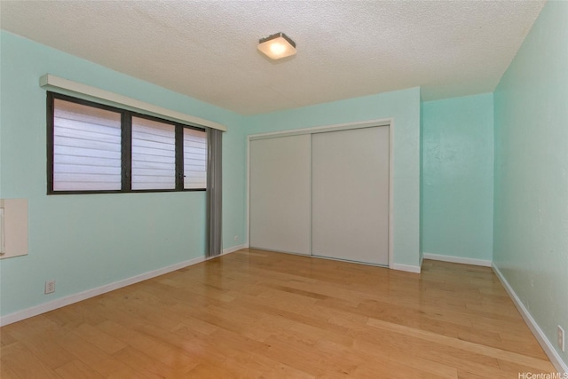 98-364 Kaonohi St Unit 11/386, Aiea, HI 96701 - unfurnished bedroom with light wood-style flooring, a closet, and a textured ceiling