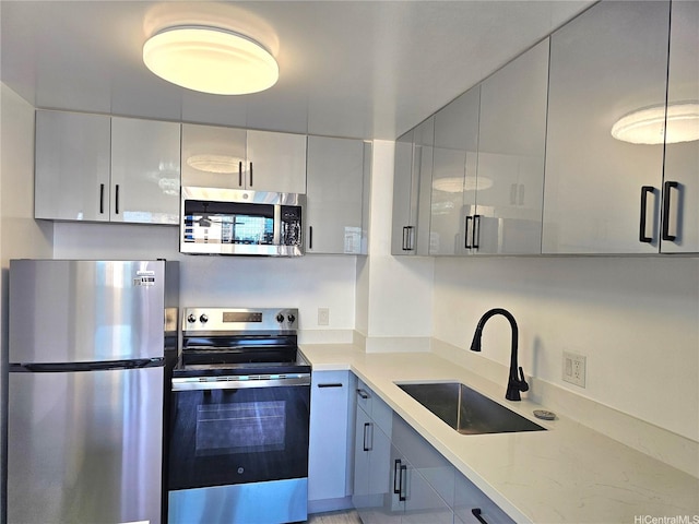 1255 Nuuanu Ave Unit E2811, Honolulu, HI 96817 - kitchen with stainless steel appliances, a sink, light stone counters, and gray cabinets