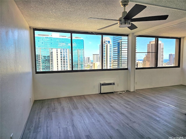 1255 Nuuanu Ave Unit E2811, Honolulu, HI 96817 - empty room featuring a ceiling fan, a textured ceiling, wood finished floors, a city view, and a textured wall