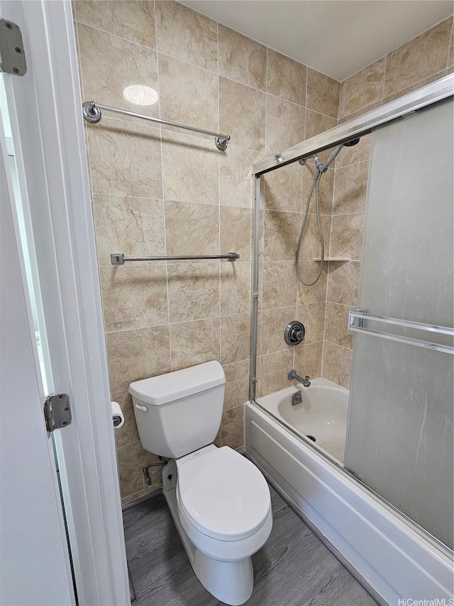 1255 Nuuanu Ave Unit E2811, Honolulu, HI 96817 - bathroom featuring toilet, shower / bath combination with glass door, wood finished floors, and tile walls