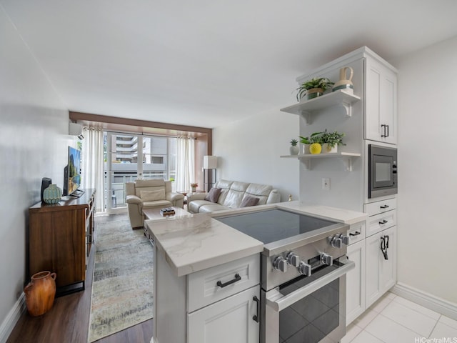 445 Kaiolu St Unit 409, Honolulu, HI 96815 - kitchen with high end stainless steel range, open shelves, black microwave, baseboards, and white cabinets